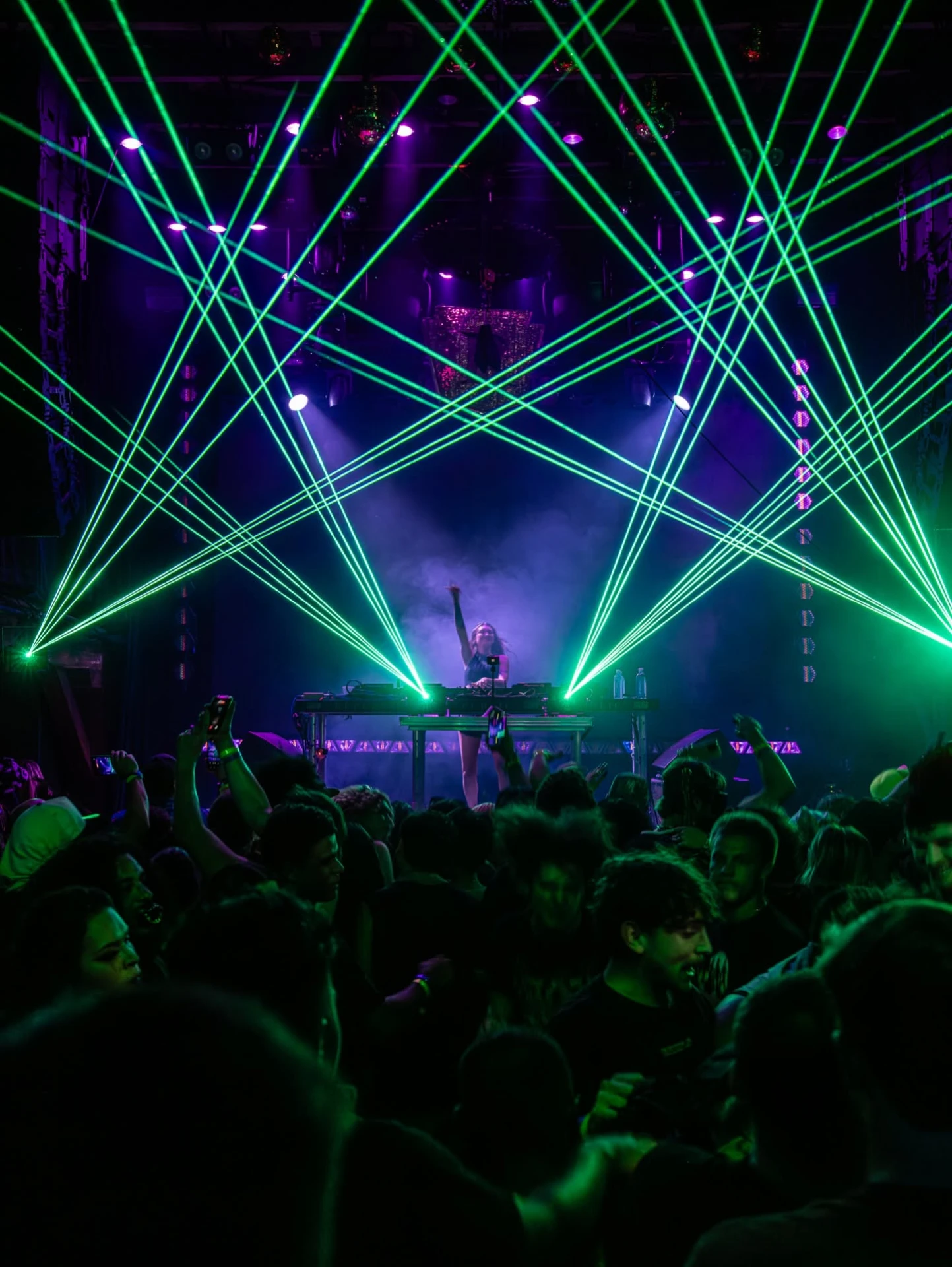 Crowd under cyan and magenta lasers at a festival stage