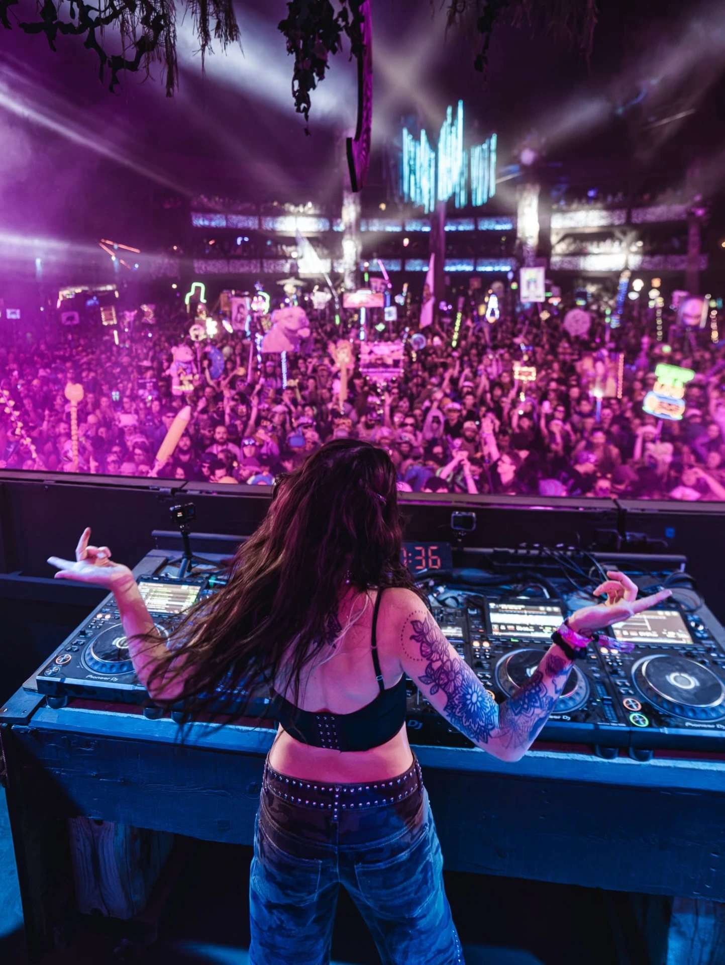 Level Up at the decks facing a packed purple-lit crowd
